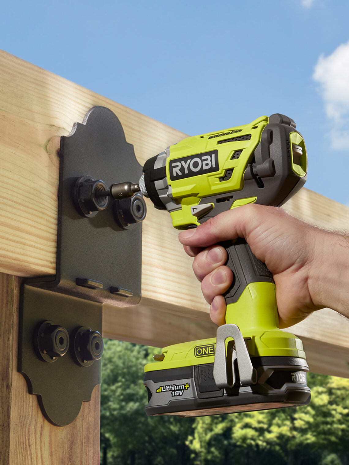 Person using a Ryobi ONE+ 18V cordless impact driver on outdoor wooden beams.