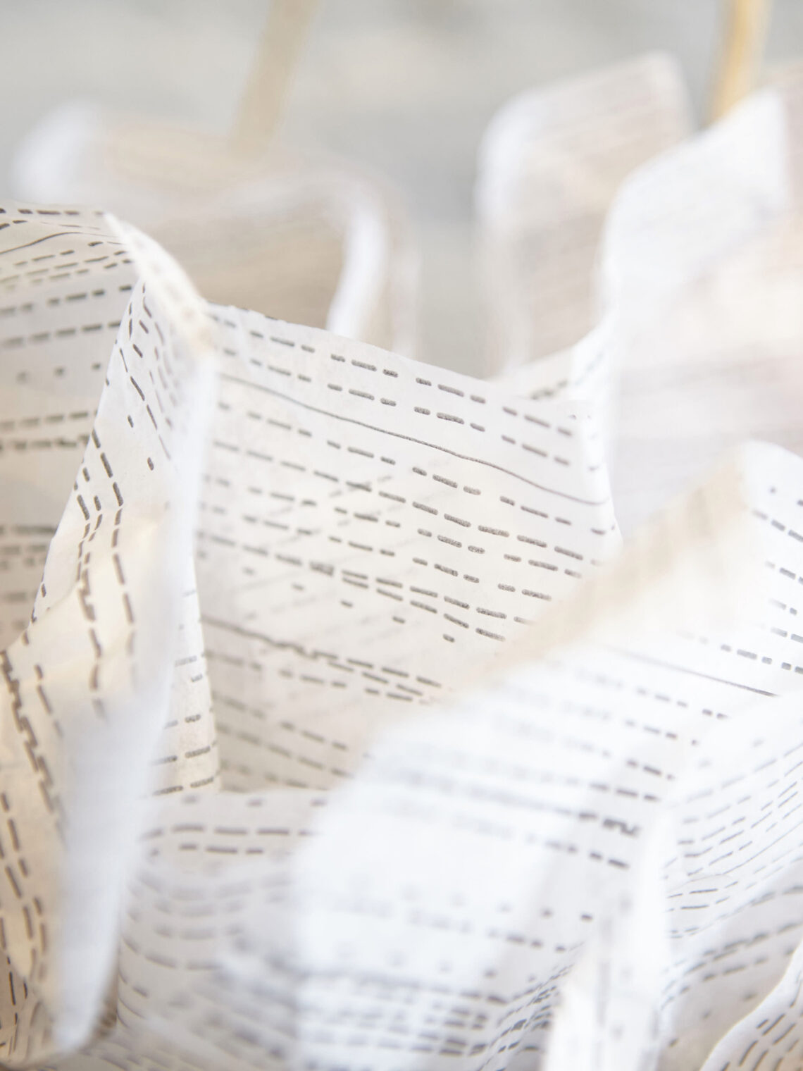 Close-up of crumpled white tissue paper packaging with Foxtrot pattern.