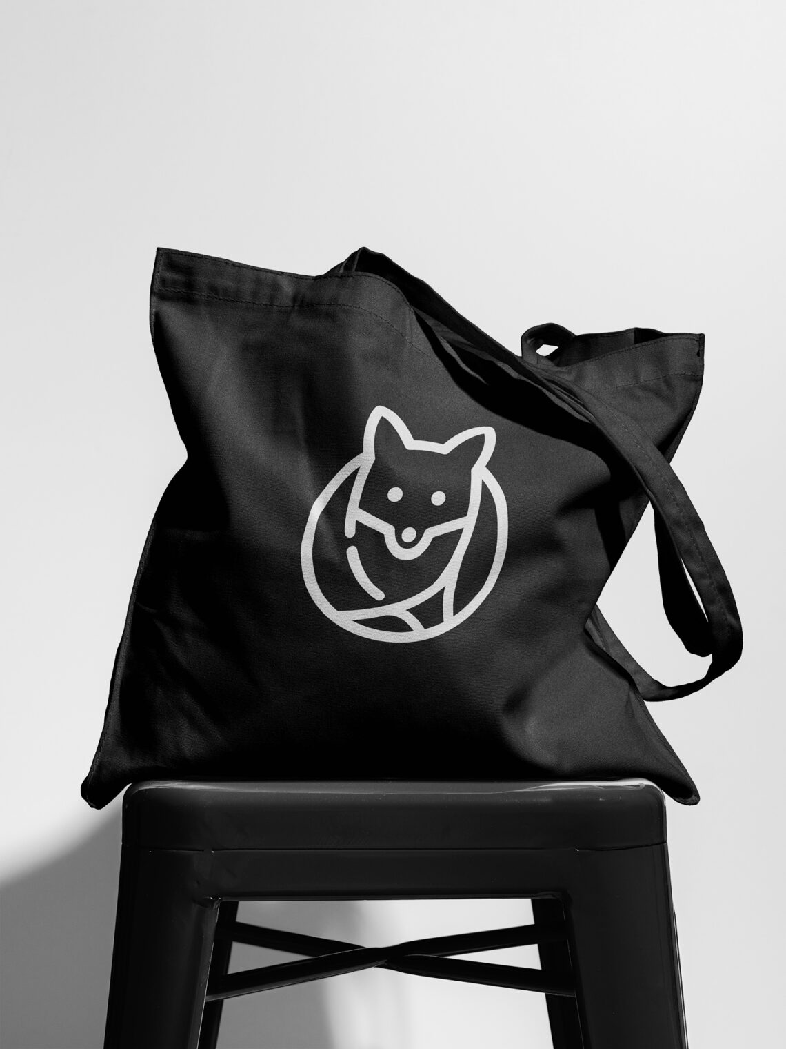 A black canvas tote bag featuring Foxtrot logo