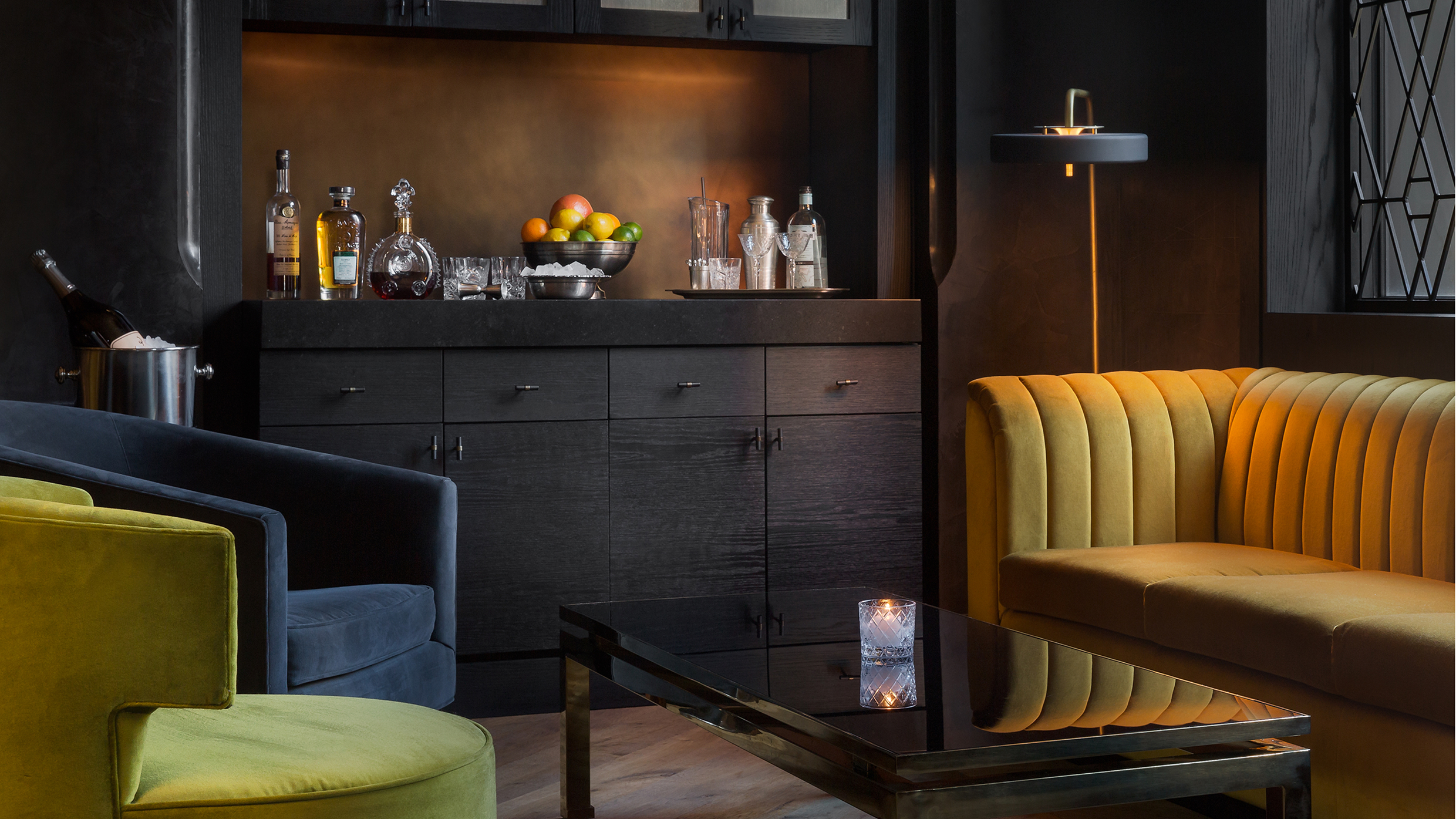 Maple & Ash private lounge with velvet seating and dark wood bar cabinet
