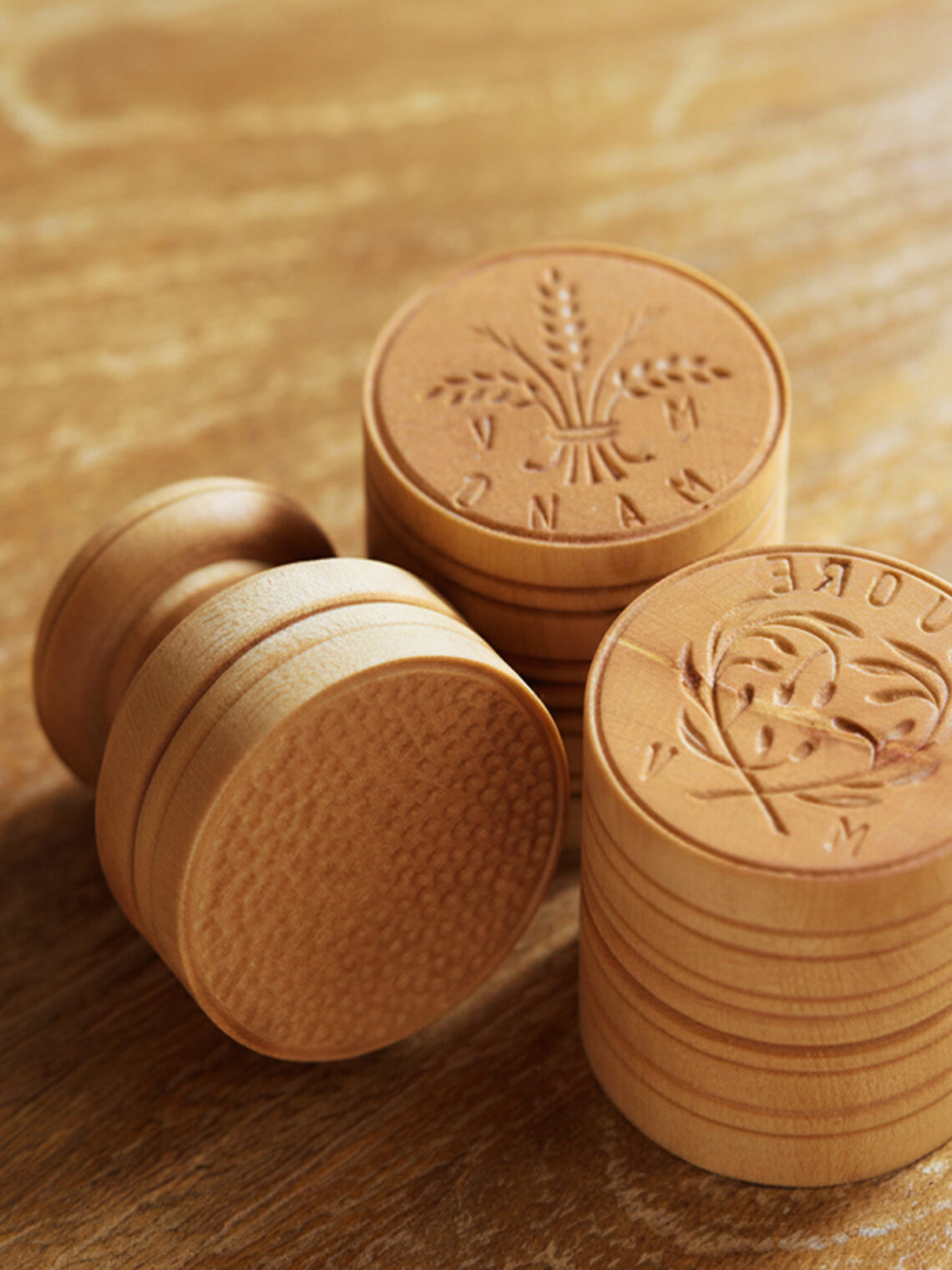 Stacks of custom-engraved wooden stamps featuring wheat and olive branch logos.