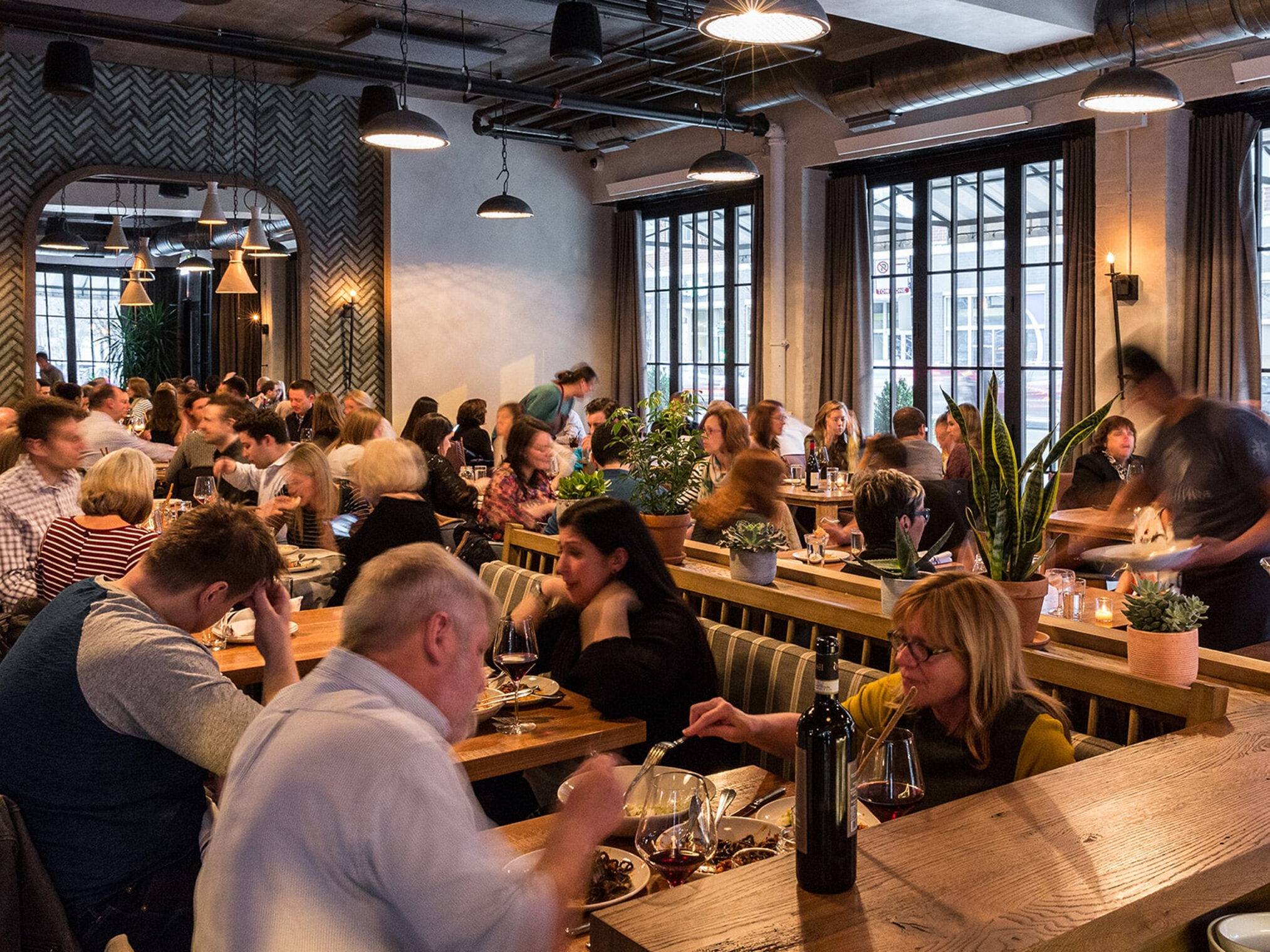 Busy dining room of Monteverde restaurant filled with patrons enjoying meals at tables.