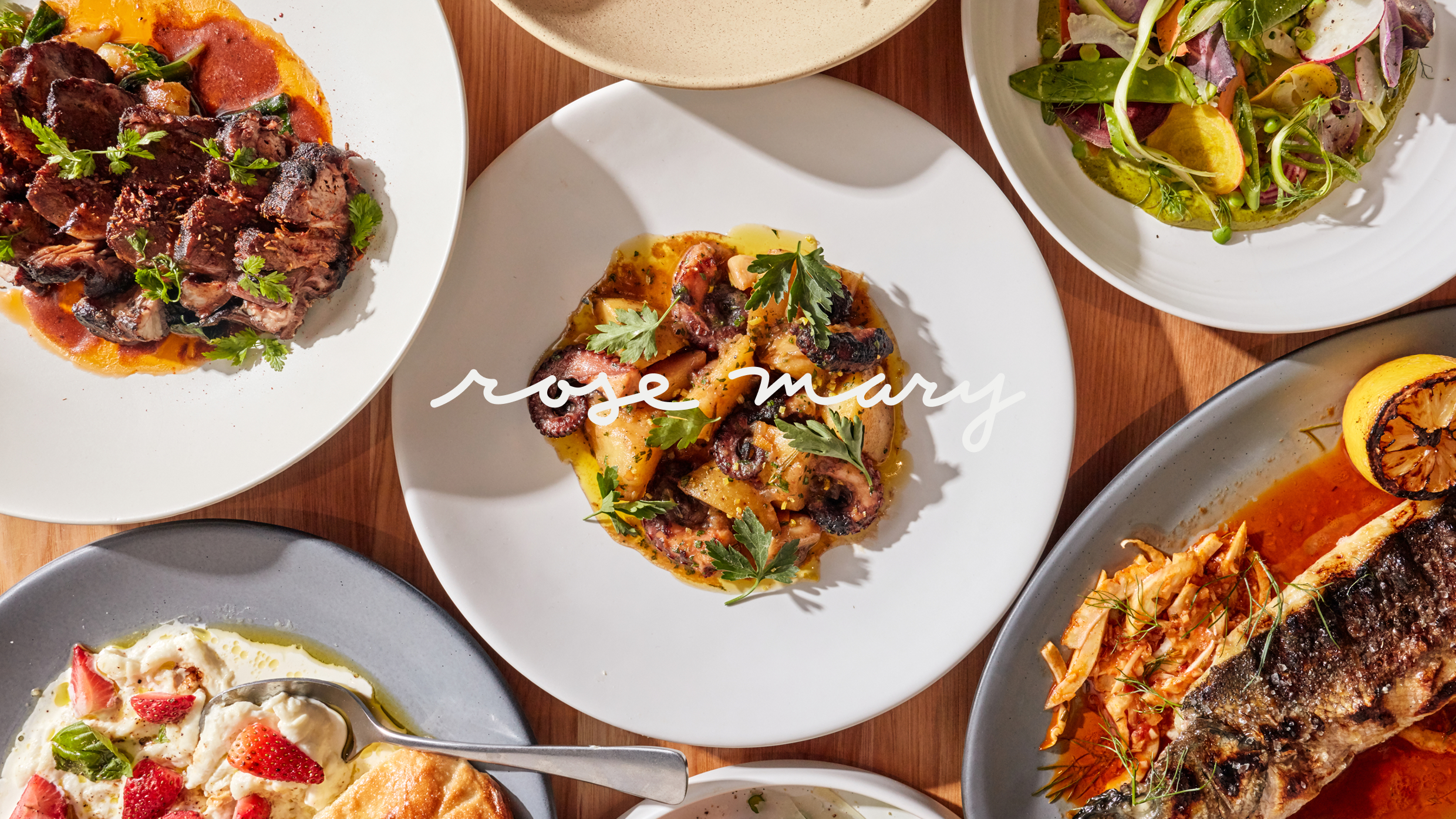 Rose Mary restaurant logo overlaid on a table spread with various plated dishes.